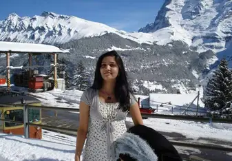 woman standing amongst snowy mountains