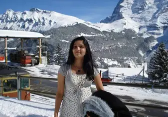 woman standing amongst snowy mountains