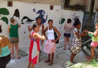 women painting mural on wall