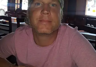 headshot of male in pink shirt