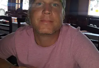 headshot of male in pink shirt