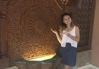 woman standing next to wood carving