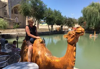 Woman rides camel near the lake in Normandy, France