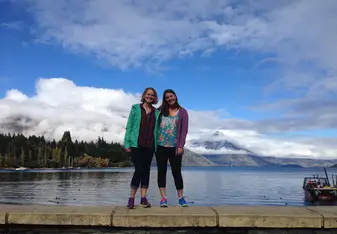 two girls standing on barrier