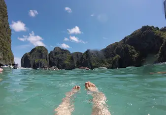 swimming in clear water with view of cliffs