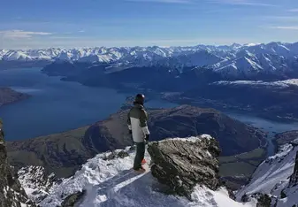 skier standing on peak overlooking valley