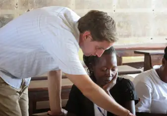 Devin Graves helps student working with Foundation for Sustainable Development 