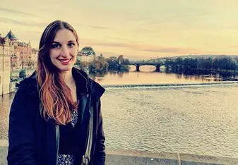 woman standing on bridge over river