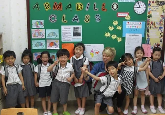 group of children in uniforms in front of board