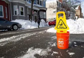 snowy street and caution sign