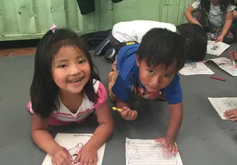 Two children coloring at Sangolqui Market