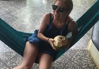 girl in hammock with coconut drink