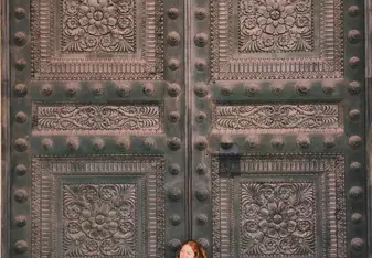 girl standing against large door