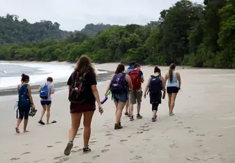 A group of USAC students walking along the beach in the Manuel Antonio National Park.