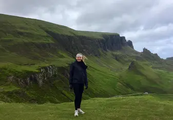 girl standing in green hills