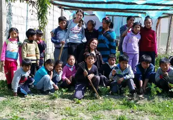 Photo of local elementary school kids and intern just after planting some organic veggies at the school garden. 