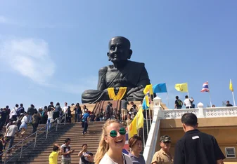 female portrait in front of statue