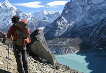 man hiking above mountain lake