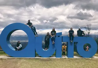Students sit on giant Quito sign located in Parque Metropolitano.