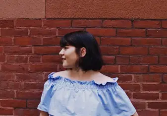 female headshot in front of brick wall