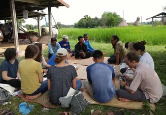 group sitting on straw mats