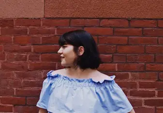 female headshot in front of brick wall