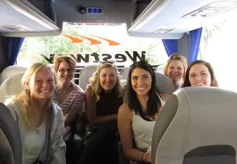 Brittney and classmates smiling big while taking a coach tour of London