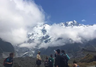 The group hiking the Hooker Valley Track, looking up at Mount Cook