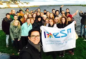 group of students smiling in ireland holding flag