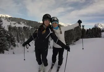 two girls skiing atop the Swiss alp mountains