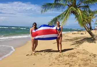 Two girls holding the Costa Rican flag in Punta Uva.