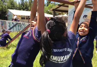 The children playing on the playground of the school. 