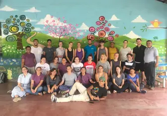 Group posing in front of a mural.