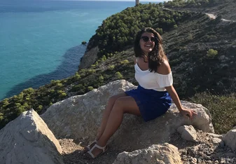 Girl sitting by the cliff.
