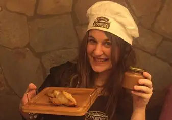 Girl in chef outfit showing food.