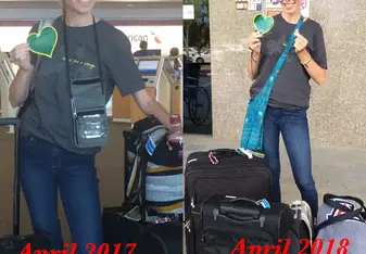Woman with luggage holds a green heart.