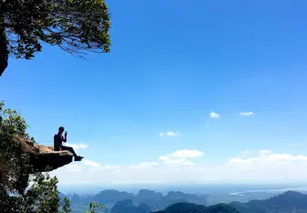 Woman sitting by a cliff.