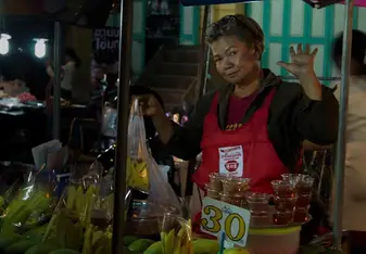 Lady selling bananas at a food stall in a busy Market