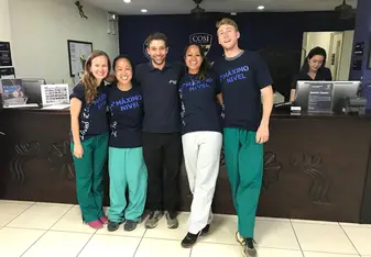 People wearing the same shirt pose for a photo.