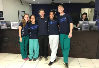 People wearing the same shirt pose for a photo.