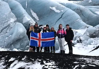 Group of people holding the Iceland flag in the Ice mountain