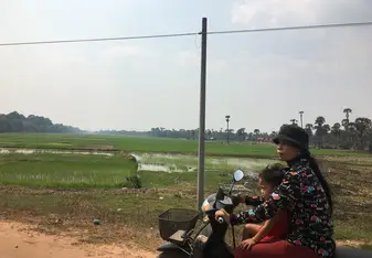 woman and child on motorbike in the countryside
