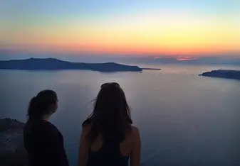 Olivia and Ming looking at a sunset in Santorini