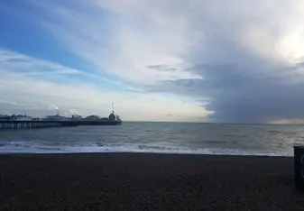 View of the English Channel and Brighton Pier where you can play carnival games and ride on carnival rides.