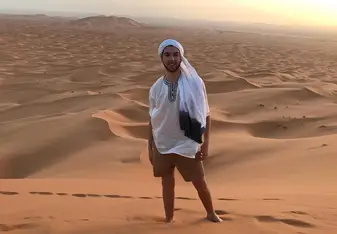 a man standing in the middle of the sand in a desert