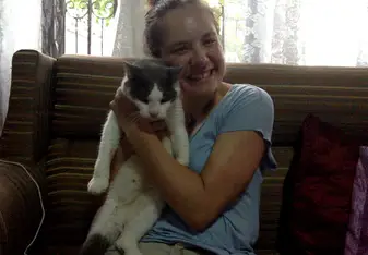 young lady cuddling a black and white cat