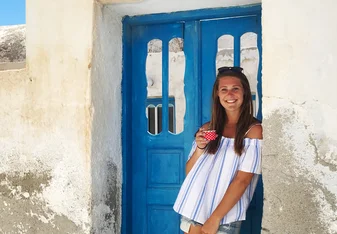 young lady standing on a blue gate 