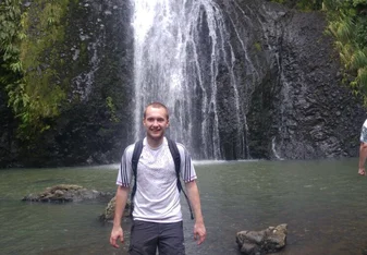 a man having his picture taken on a beautiful falls