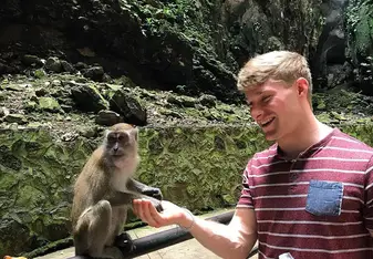 Guy holding monkey's hands.