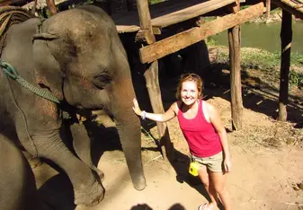 A lady touching the elephant's trunk